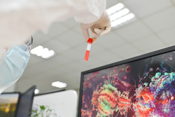 Asian male doctor wearing protective suits holding a positive blood test result for the new rapidly spreading Coronavirus (nCoV, Covid-19). International standard biological laboratory concept.