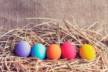 easter painted eggs in basket on fabric background