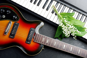 Fototapeta na wymiar Synthesizer keyboard, electric guitar and a bouquet of flowers.