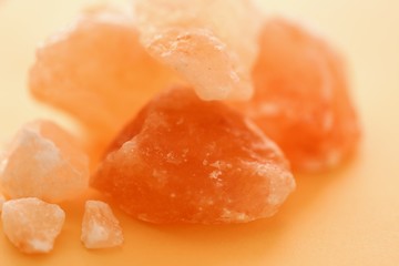 Pink Himalayan salt  pieces set on a orange blurred background. Saindhava lavana or Himalayan .Pink rock salt.Pink salt minerals in rock from Himalaya