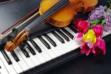 Fototapeta premium Piano keyboard, violin with a bow and a bouquet of flowers.