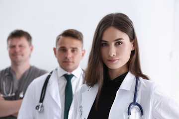 Fototapeta premium Group of medics proudly posing in row and looking in camera smiling. High level service, best treatment 911 professional healthy lifestyle therapeutist consultation physical emergency concept