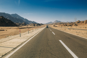 The road in the middle of the desert and mountains.