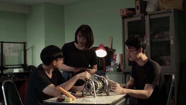 Asian chief club of engineer advice engine describes the operation of the engine parts with student engineering intern at the lab. Concept of gadget, development and productivity.