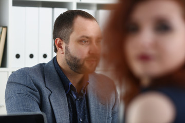 Fototapeta premium young beautiful red haired woman sit at table in office in cabinet of her boss first place of work concept
