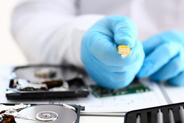 A male hand in blue protective gloves holds a network connector. The LAN constructor deconstructs...
