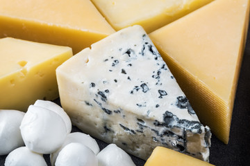different varieties of cheese, hard, brine, soft and with mold on the table