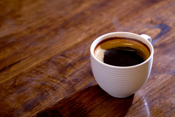 Cup of fresh coffee on wooden background