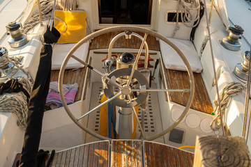 motorboat captain navagation wheel with warm sunrise sunset lighting