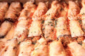 rows of Italian ricott manicotti pasta tubes, ridged, stuffed and baked