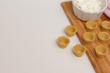 Tartlets with custard or cottage cheese. Empty tartlets or pie on a white table. Food lay flat. The view from the top. The concept of preparing food for the holiday table.