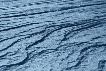 Classic Blue background. Color of the year 2020. Texture of the snow. Snow close-up. Natural snow background.