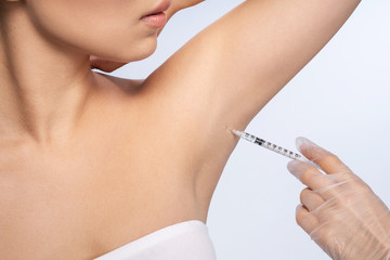 Professional cosmetologist doing armpit botox for client