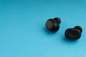 Wireless earbuds or earphones on blue background