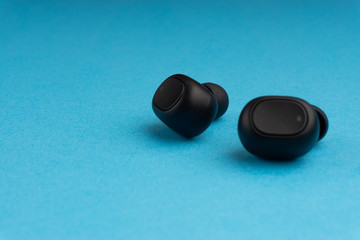 Obraz na płótnie Canvas Wireless earbuds or earphones on blue background