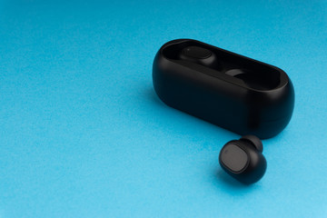 Wireless earbuds or earphones on blue background