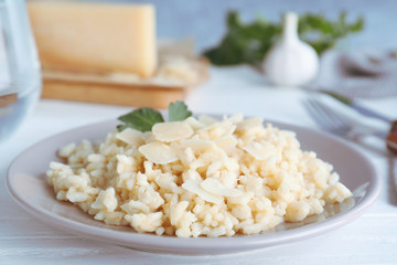 Delicious risotto with cheese on white wooden table, closeup
