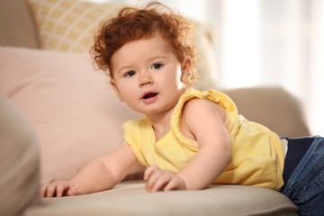 Portrait of cute little child on sofa at home