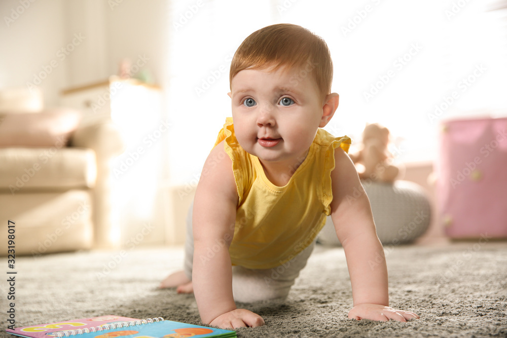 Wall mural Cute little baby girl crawling at home