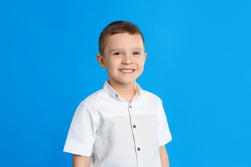 Portrait of cute little boy on blue background