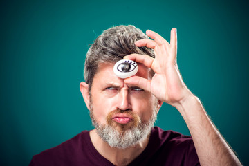 A portrait of bearded man holding egg with drawing eye behind forehad as third eye symbol.