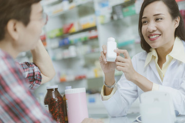 illness asia patient women and pharmacist or medicine, pharmaceutics, health care and people concept. Pharmacist  discusses prescription medication with illness asian patient senior women or customer