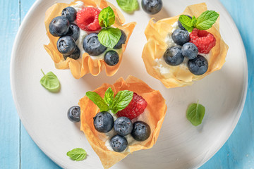 Sweet phyllo cups with blueberries, raspberries and whipped cream