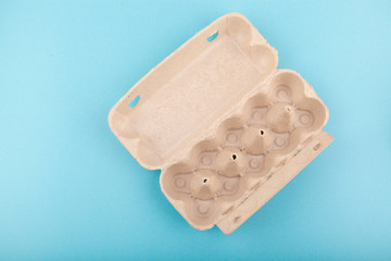 Egg Chicken eggs. Top view of an open empty gray box . Isolated on a blue background. The concept of a healthy lifestyle, getting pure protein. Proper Breakfast. Run out of eggs Shortage of chicken