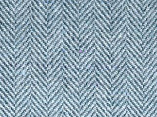 Elegant blue-gray wool fabric with zigzag stripes. Tweed suit by herringbone, texture of the background. Expensive men's suit made of fabric. High resolution