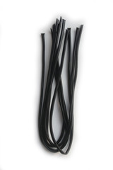 Licorice ribbons isolated on white background. Black candies on white