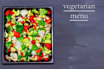 Stewed vegetables on a baking sheet on a table with text Vegetarian menu.
