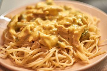 Close up fried mushrooms and chicken fillet in cheese sauce and spaghetti.