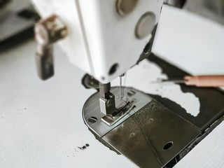 closeup sewing machine head parts needle holder.