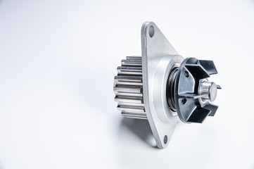 New metal automobile pump for cooling the engine of a water pump on a gray background. The concept of new spare parts for the car engine