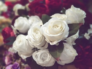 Fake flowers  for Interior.Artificial roses made by fabric and plastic use decorated.14 February is Valentine day. love wallpaper.White roses bouquet in a vase