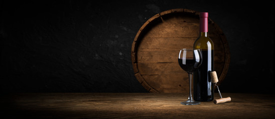 Fototapeta Expensive wine bottles collection and wooden barrel in the cellar, wine tasting and production concept obraz