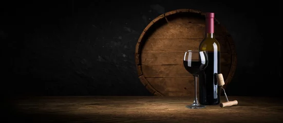 Fotobehang Dure wijnflesseninzameling en houten vat in de kelder, wijnproeverij en productieconcept © kishivan