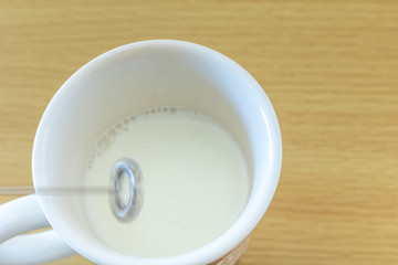 Fototapeta na wymiar ミルク泡立て器と牛乳入りコップ