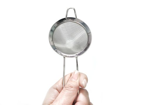 Woman Is Holding Stainless Steel Colander Isolated On White Background With Copy Space. Kitchenware Used For Filtering Raw Materials