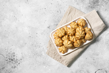 Lemon cookies with poppy seeds in a white ceramic plate on the gray kitchen table. Shortbread. Space for text