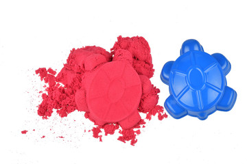 Kinetic sand with molds on a white background, top view