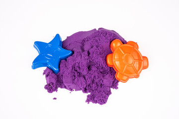 Kinetic sand with molds on a white background, top view
