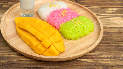 Three colors of sticky rice and ripe mango (Thai dessert).