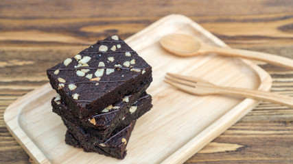 Brownies cake, spoon, and fork on a wooden table.