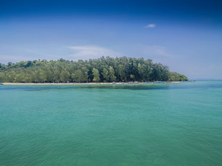 Sea view of Pine forest on green island around with blue-green sea and blue sky background, Bamboo island, a part of Phi Phi islands, Krabi, southern of Thailand.