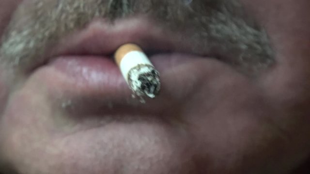 eine Zigarette im Mund, die qualmt