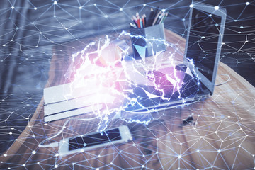Double exposure of table with computer and brain hologram. Data innovation concept.