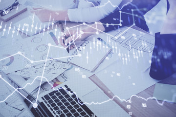 A woman hands writing information about stock market in notepad. Forex chart holograms in front. Concept of research. Double exposure