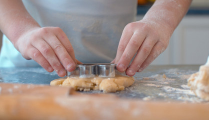 Girl making cookies with a cookie cutter
