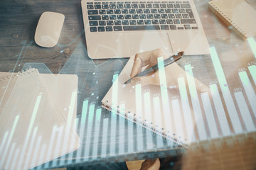 Financial graph displayed on woman's hand taking notes background. Concept of research. Multi exposure